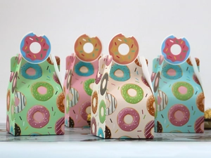Close-up of assorted donut-themed bakery boxes with unique cutout handles and colorful prints