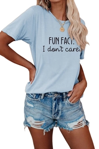 Detail of light blue t-shirt with 'Fun Fact I don't care' print and ripped denim shorts
