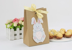 Easter kraft paper gift bag with blue rabbit patch and yellow satin ribbon bow detail
