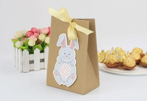 Detail of kraft paper gift bag with striped texture, satin ribbon bow, and blue bunny tag