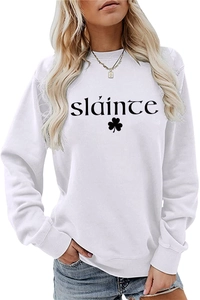 Détail du lettrage Sláinte et de l'imprimé trèfle sur un sweat-shirt blanc à col rond