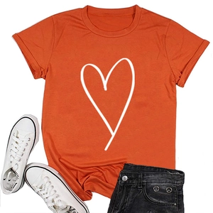 T-shirt orange à motif cœur disposé à plat avec short en jean et baskets blanches