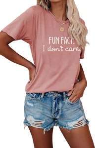 Detail view of pink t-shirt with Fun Fact I don't care text and ripped denim shorts
