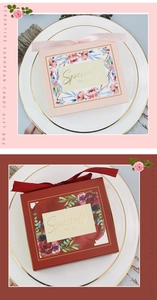 Detailed close-up of pink and wine red drawer candy boxes with floral prints and silk ribbons