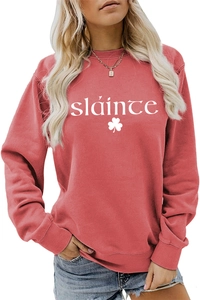 Détail du sweat-shirt rouge corail avec texte sláinte blanc et motif trèfle imprimé
