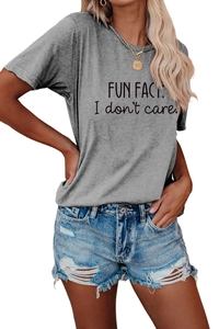 Detail of grey graphic t-shirt with 'FUN FACT' print and ripped denim shorts on model