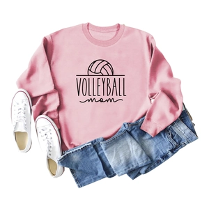 Flat lay of a pink volleyball mom sweatshirt with casual denim shorts and white sneakers