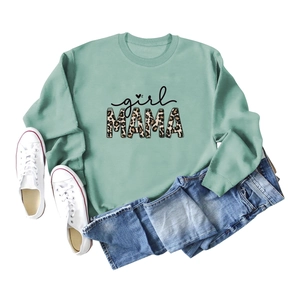 Flat lay of mint green sweatshirt with leopard print MAMA text and canvas sneakers