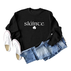 Mise à plat du sweat noir avec inscription sláinte blanche et motif trèfle