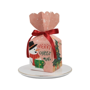 Pink Christmas gift box with snowman print and red satin ribbon bow on white plate