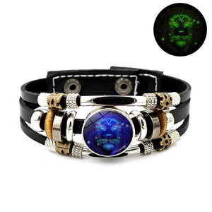 Detailed close-up of a layered leather Leo zodiac bracelet with a green luminous glow effect