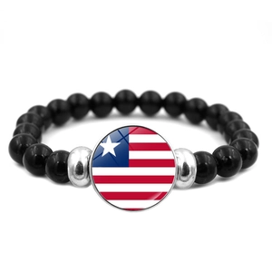 Detailed macro view of ethnic beaded bracelet with Liberian flag glass dome charm