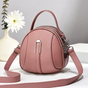 Pink round leather handbag with three-layer zippers and adjustable crossbody shoulder strap