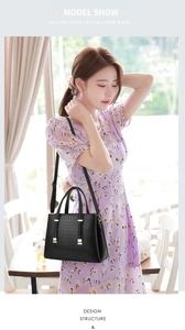 Détail du sac à main noir à motif crocodile élégant avec des accessoires dorés chic