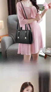 Détail du sac à main noir avec logo gaufré et finitions métalliques dorées