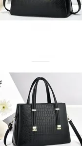 Détail du sac à main noir à motif crocodile avec boucle dorée et sac à texture tressée