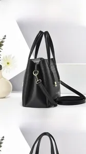 Vue latérale du sac à main noir en simili cuir crocodile avec détails dorés élégants