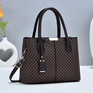 Close-up of brown quilted leather tote bag with gold metal accents and shoulder strap