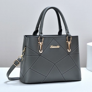 Détail du sac à main en cuir synthétique gris avec surpiqûres losanges et logo doré