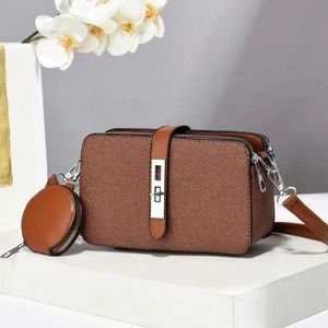 Close-up of brown textured multi-layer crossbody bag with mini round coin purse detail