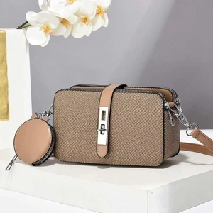 Detailed shot of khaki textured crossbody bag with matching round coin purse and silver lock