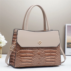 Détail de la texture crocodile sur un sac à main patchwork marron et beige pour femme