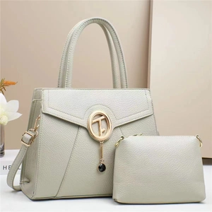 Detail view of stylish sage green pebbled leather tote set with gold ring clasp charm