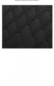 Close-up of black quilted leather handbag featuring heart embroidery and diamond stitching