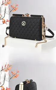 Detail view of heart-shaped quilting and golden logo on black luxury evening bag