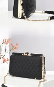 Detail of black quilted handbag featuring a luxury crystal clasp and gold chain strap