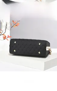 Detail view of the black quilted handbag base with four golden protective metal feet