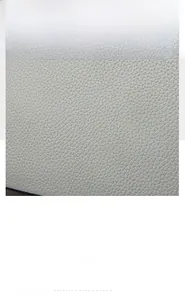 Close-up of premium light gray PU leather with a realistic lychee grain texture