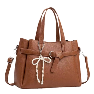 Brown lychee leather handbag with double handles and a pearl butterfly charm accessory