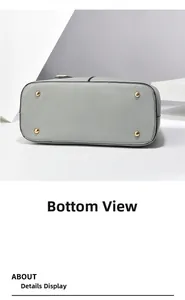 Close-up of the grey pebble leather bag bottom with four protective gold metal feet studs