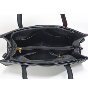 Top-down view of spacious black shoulder bag interior with multiple compartments and gold zippers