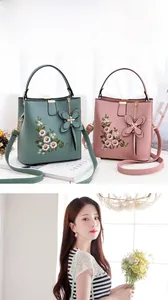 Détail d'un sac seau brodé avec motifs floraux et breloque noeud en cuir