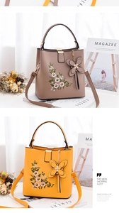 Détail de la broderie florale sur des sacs seaux avec pendentifs papillon en cuir