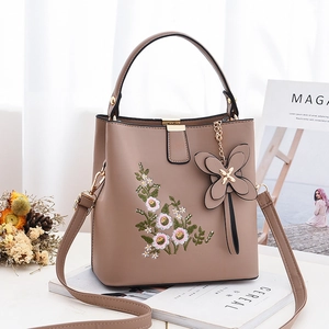 Sac seau kaki élégant avec broderie florale et bandoulière sur fond blanc épuré