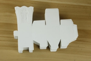 Detail of white paper chair candy box with embossed patterns on wooden table
