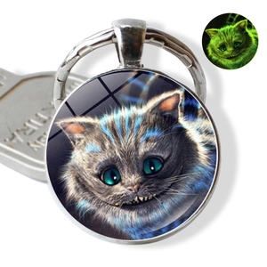 Luminous Cheshire Cat glass keychain pendant showing green glow effect in dark