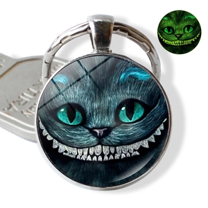 Glow-in-the-dark Cheshire Cat keychain with luminous glass gem and metal ring