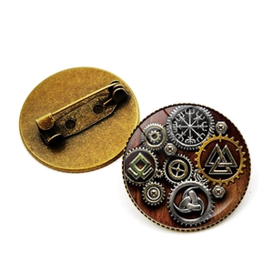 Close-up of vintage Viking compass brooch with gear details and bronze base pin