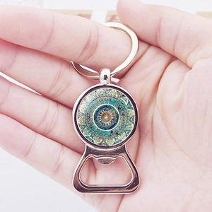 Portachiavi apribottiglie mandala con ciondolo boho tenuto nella mano