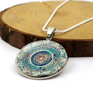 Mandala flower glass dome pendant necklace with silver snake chain on wooden background