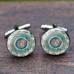 Silver cufflinks with mandala floral patterns set on a rustic wooden background texture