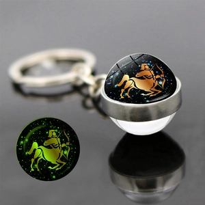 Luminous Sagittarius double-sided glass ball keychain showing green glow in the dark