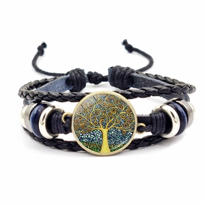 Detail eines Vintage-Lederarmbands mit Lebensbaum-Cabochon und geflochtenen Elementen