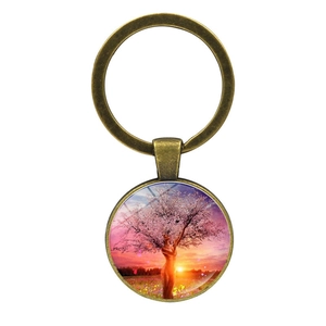 Gros plan d'un porte-clés Arbre de Vie en bronze avec pendentif en verre et arbre à fleurs roses