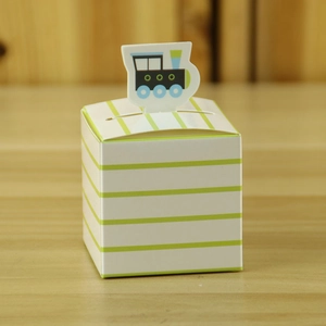 Close-up of baby party candy box with green stripes and cute paper train topper