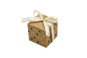 Close-up of kraft paper gift box with gold dots and white ribbon bow decoration